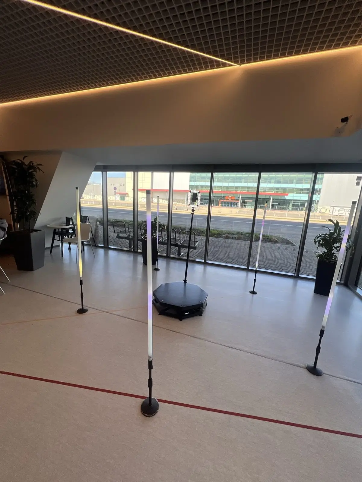 360 video spineris ar melnu platformu un LED gaismas stabiem gaišā zālē pie lieliem logiem