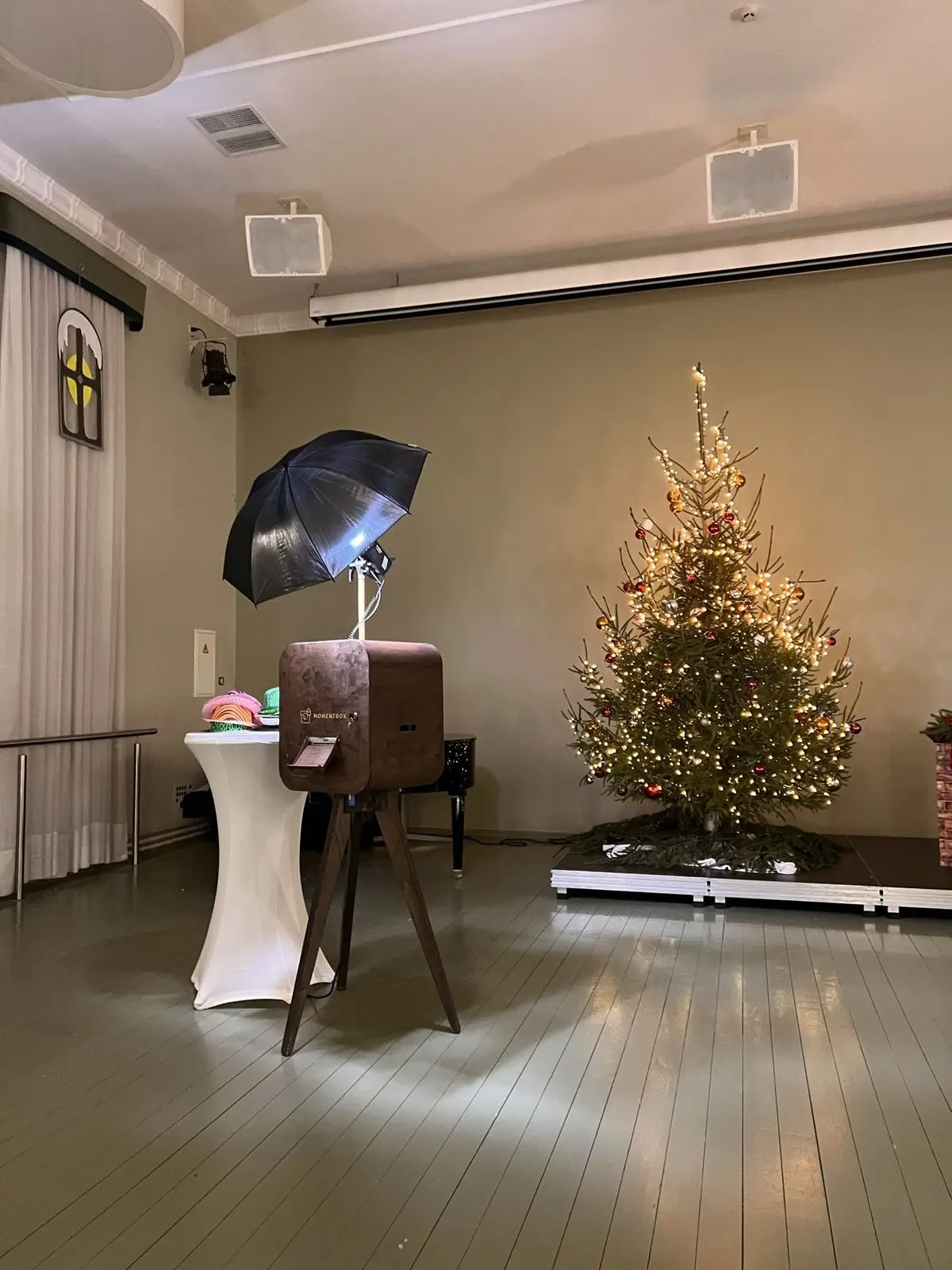 Foto kaste ar lietussarga zibspuldzi zālē ar Ziemassvētku egli